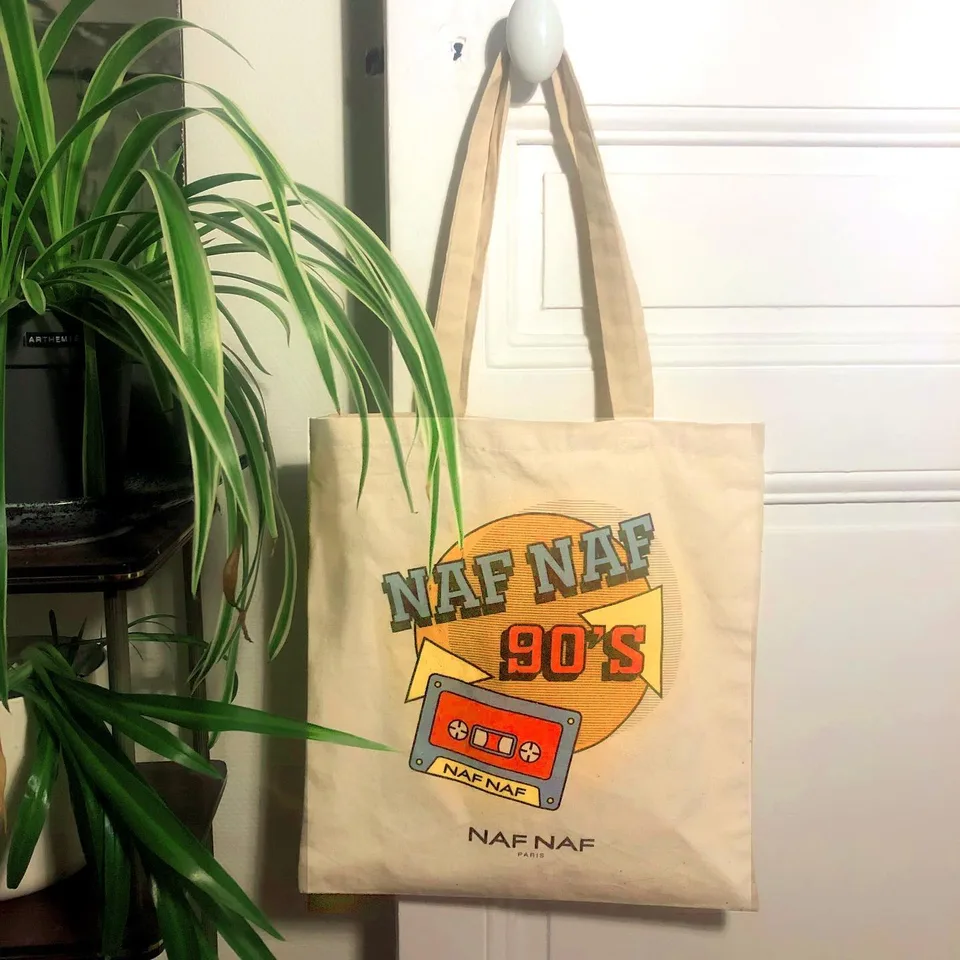 Tote bag Naf Naf « 90's » à motif cassette, suspendu à une porte