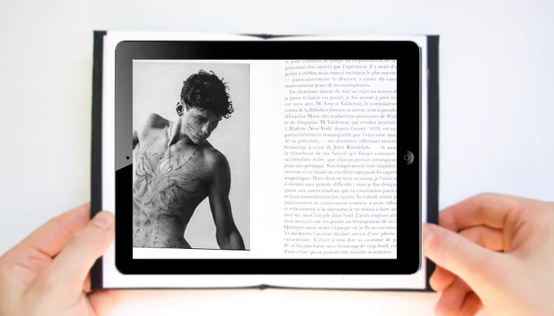 Tablette tenue au-dessus du livre : la photographie s'anime en réalité augmentée